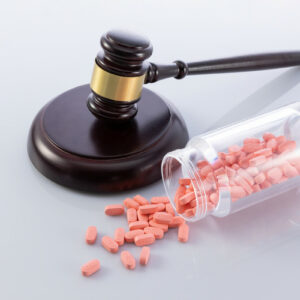 the judge's gavel and pills falling from a jar - concept of illegal sale of medicines